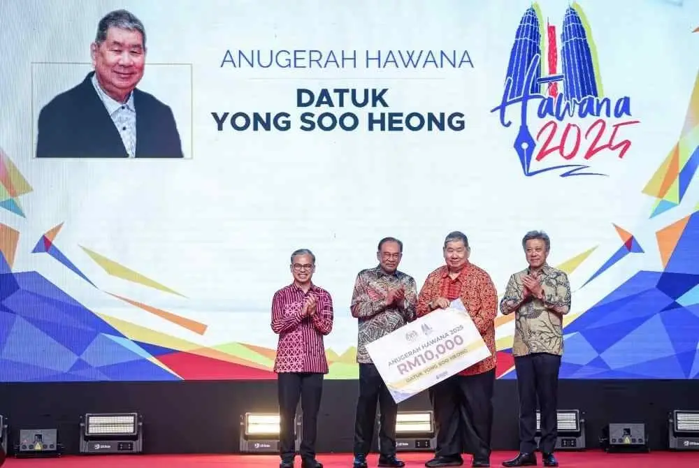 Anwar menyampaikan Anugerah Hawana 2025 kepada Soo Heong (dua, kanan) pada majlis kemuncak sambutan Hari Wartawan Nasional 2025 di Dewan Merdeka, WTCKL pada Sabtu. Foto Bernama