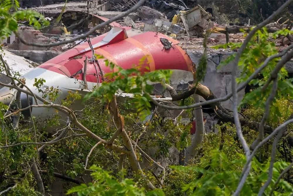 Ekor pesawat sedang dikeluarkan dari sisa runtuhan nahas penerbangan Air India yang berlaku pada 12 Jun, dirakam di kawasan perumahan berhampiran lapangan terbang di Ahmedabad pada 14 Jun 2025. Foto AFP