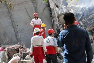 Sukarelawan Bulan Sabit Merah Iran sedang menjalankan kerja-kerja bantuan di sebuah kawasan kejiranan di Tehran yang dilaporkan terkena serangan Israel. Foto AFP