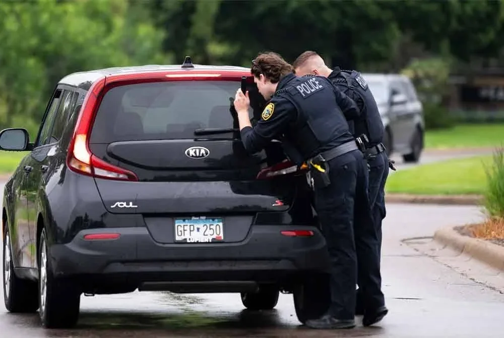 Anggota polis Brooklyn Park memeriksa sebuah kenderaan yang memasuki kawasan kejiranan susulan insiden tembakan tragis yang mengejutkan negeri itu. Foto AFP