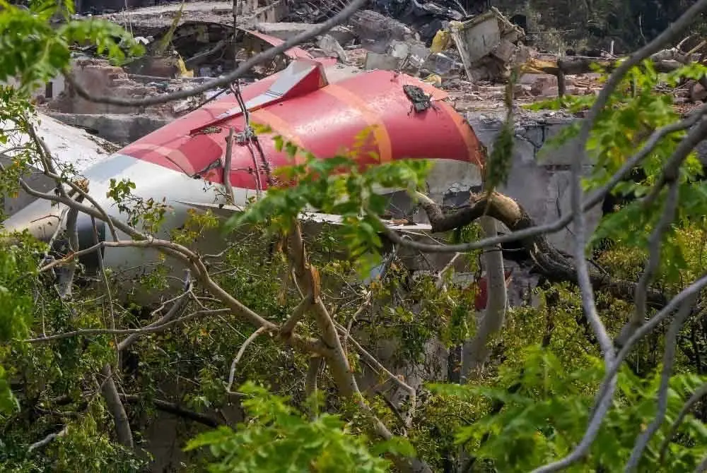 Ekor pesawat sedang dikeluarkan dari sisa runtuhan nahas penerbangan Air India yang berlaku pada 12 Jun, dirakam di kawasan perumahan berhampiran lapangan terbang di Ahmedabad pada Sabtu. Foto AFP