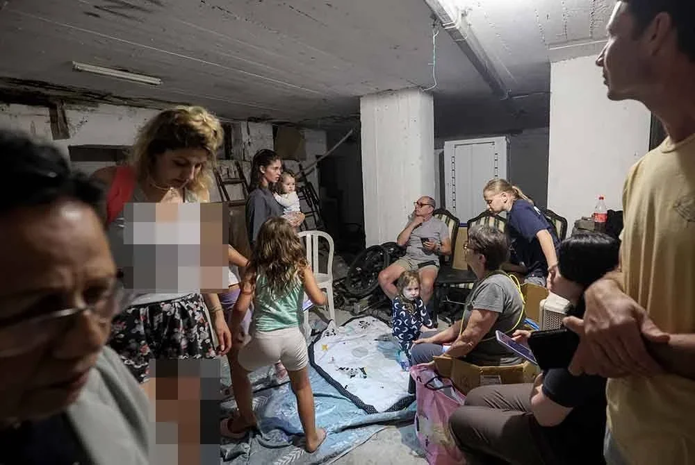 Orang ramai berlindung di sebuah tempat perlindungan ketika siren amaran dibunyikan susulan serangan peluru berpandu dari Iran di bandar Bat Yam, selatan Tel Aviv. Foto AFP