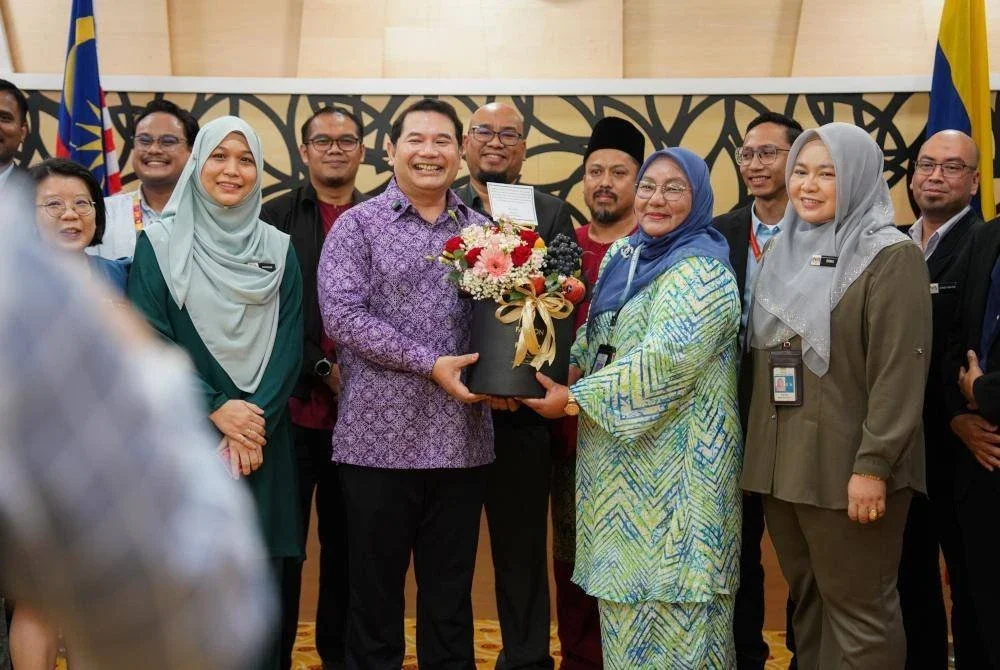 Tersenyum lebar Rafizi menerima cenderahati daripada kakitangan di bawah Kementerian Ekonomi. FOTO: Facebook Rafizi Ramli.