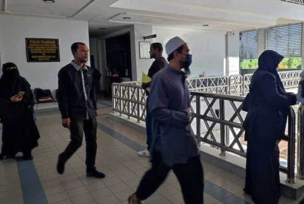 Shahril Bani (depan) ketika di pekarangan Mahkamah Sesyen Sungai Petani pada Selasa.