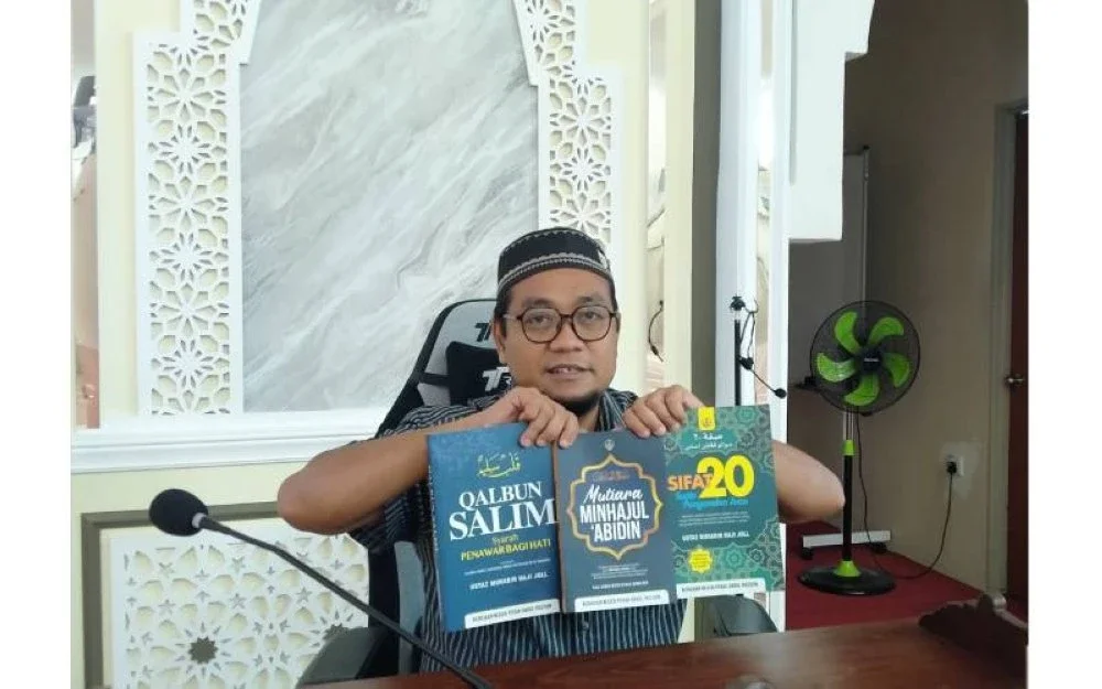 Mohd Fairoz Affendy menunjukkan tiga kitab yang disediakan oleh Kerajaan Negeri Perak kepada masjid-masjid di Perak.