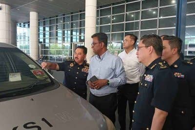 Muhammad Kifli (kiri) menunjukkan sebuah teksi yang ditahan kerana melakukan kegiatan ulat di KLIA, Sepang pada Rabu.