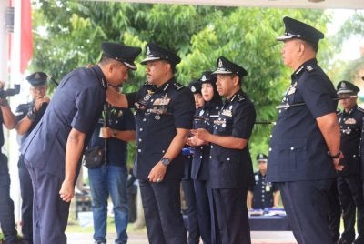 Mohd Yusoff (tengah) memakaikan pangkat kepada pegawai pada Majlis Perhimpunan Bulanan IPK.