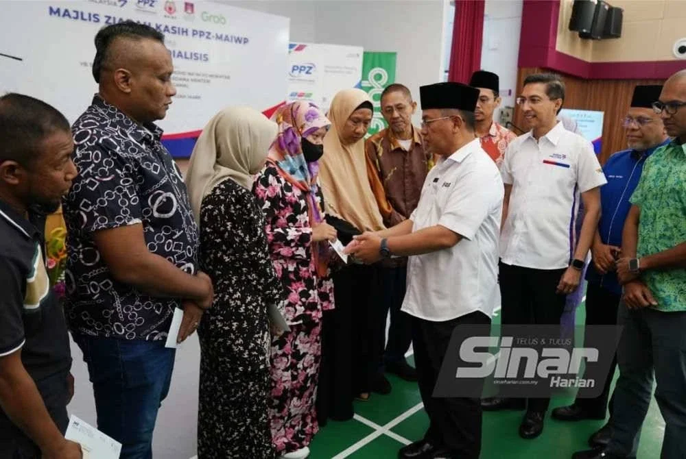 Mohd Na'im beramah mesra dengan penerima sumbangan pada majlis Ziarah Kasih PPZ-MAIWP pada Khamis. Foto Sinar Harian ROSLI TALIB
