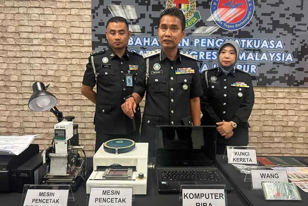 Wan Mohammed Saupee (tengah) menunjukkan antara dokumen dan peralatan dirampas dalam serbuan dijalankan sebelum ini.