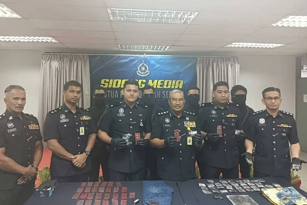 Norhizam (tiga dari kanan) menunjukkan dadah dirampas daripada empat suspek yang bertindak sebagai 'transporter' di Sepang, Selangor pada Rabu.