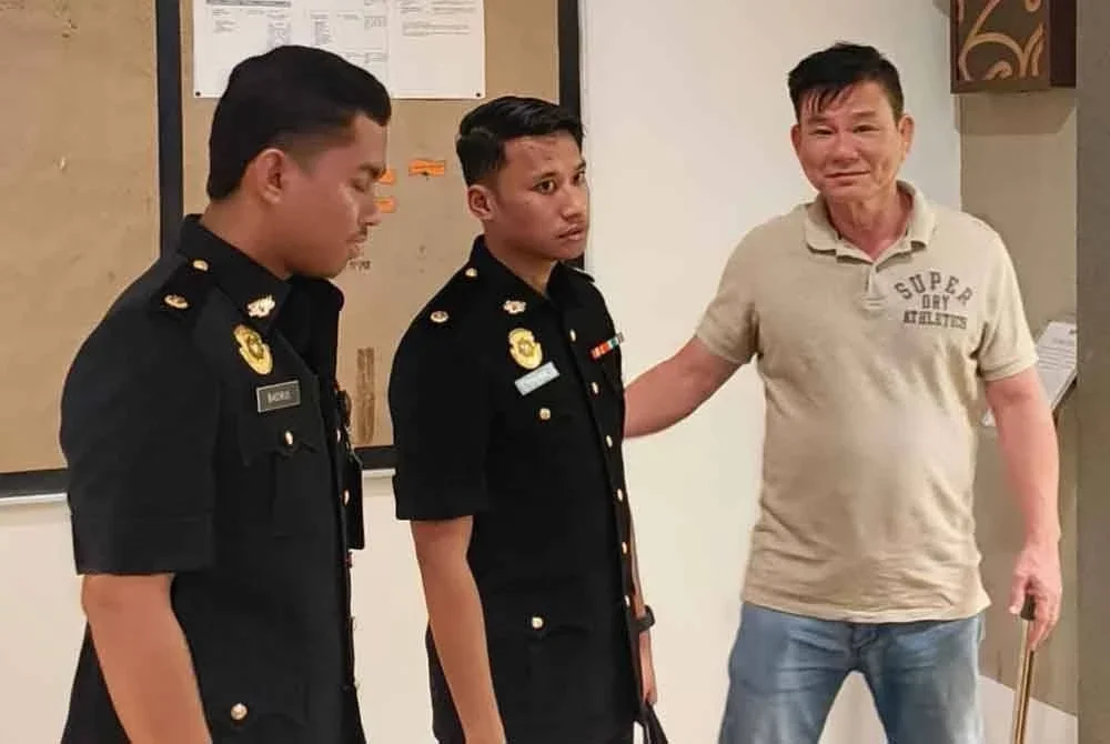 Lye Seng (kanan) ketika dibawa keluar dari Mahkamah Sesyen Shah Alam pada Jumaat.