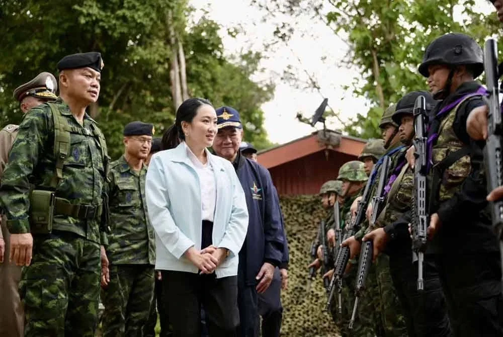 Paetongtarn (tengah) bertemu dengan anggota tentera di Markas Operasi Morakot di wilayah Ubon Ratchathani pada Jumaat selepas beliau kini berdepan desakan supaya berundur.