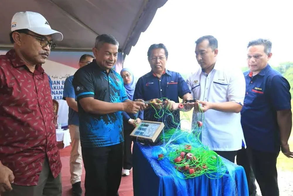 Azman (dua dari kiri) menunjukkan kod QR yang dipasang pada peralatan tangkapan ikan nelayan.