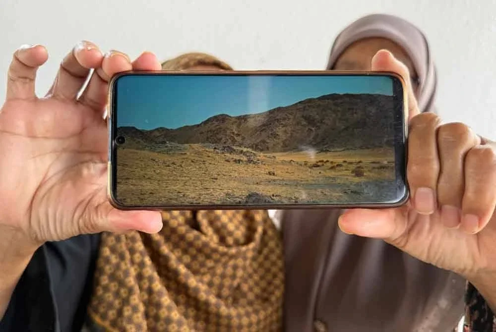 Sharifah (kanan) bersama kakak iparnya menunjukkan laluan yang perlu diredahnya untuk memasuki Makkah.