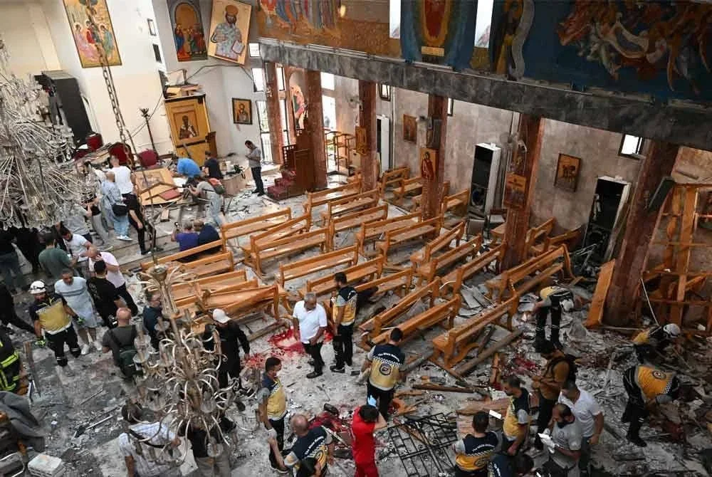 Orang ramai dan pasukan penyelamat memeriksa kerosakan di lokasi kejadian yang dilaporkan sebagai serangan berani mati di Gereja Saint Elias di kawasan Dwelaa, Damsyik. Foto AFP