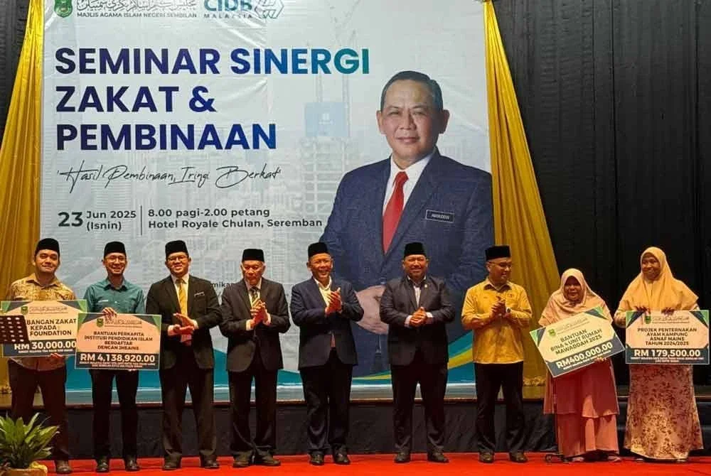 Aminuddin (tengah) bergambar bersama wakil penerima bantuan zakat.