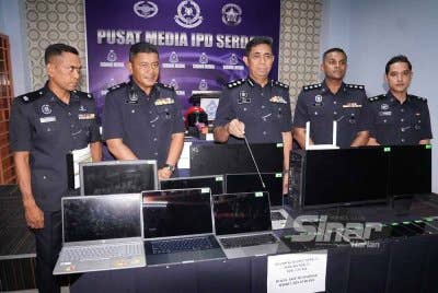 Muhamad Farid (tengah) menunjukkan pelbagai barangan sindiket penipuan pelaburan yang dirampas. - FOTO: SINAR HARIAN/ ROSLI TALIB