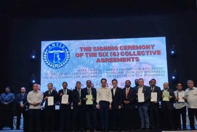 Steven (depan, tengah) menyaksikan pemeteraian enam perjanjian kolektif antara AMESU dan majikan sektor perladangan pada Isnin.