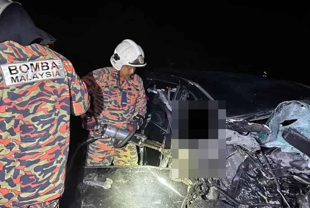 Anggota bomba cuba mengeluarkan mangsa tersepit akibat kemalangan tersebut.