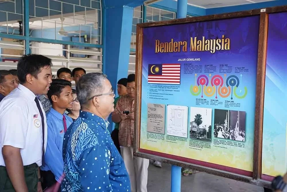 Aaron meninjau bahan arkib yang dipamerkan di sekolah.