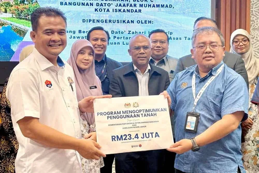 Zahari (kiri) bersama bersama Penolong Setiausaha KPKM, Mohd Fahmi Kamal Mohamed Noh menunjukkan simbolik peruntukan KPKM kepada Johor selepas Mesyuarat Jawatankuasa Kerja Sekuriti Makanan Negeri Johor (JSMNJ) Bil. 2/2025 pada Selasa.