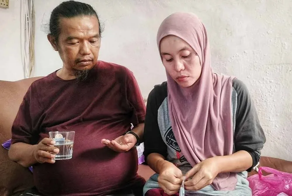 Agus (kiri) yang kini memikul tanggungjawab sebagai ketua keluarga sentiasa berada di sisi suaminya, Suhaimi yang kini tidak boleh bekerja akibat penyakit dihidapinya.