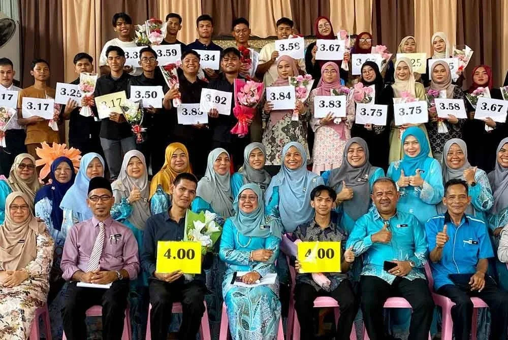 Alam Haikal (tiga, kiri duduk) meraikan kejayaannya yang muncul sebagai pelajar cemerlang STPM SMK Machang bersama guru dan rakan-rakan yang lain.