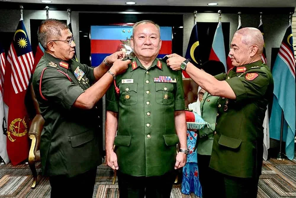 Mohd Nizam (kanan) memakaikan pangkat kepada Johnny Lim (tengah) yang melakar sejarah sebagai pegawai kanan ATM berbangsa Cina pertama dinaikkan pangkat ke Leftenan Jeneral.