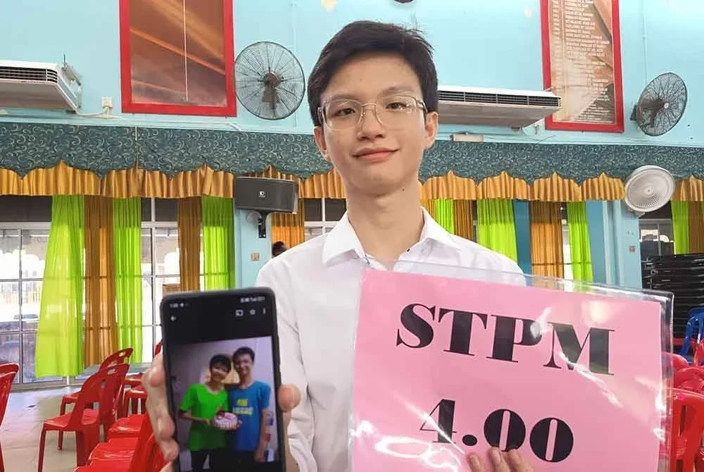 Yu Keat menunjukkan gambar bersama mendiang ibunya yang dirakam dua tahun lalu ketika ditemui pada majlis pengumuman keputusan STPM di SMKSS Kuala Terengganu.