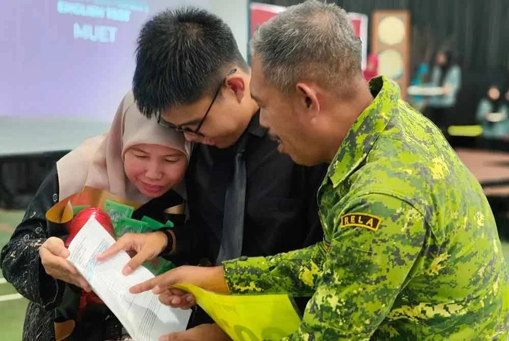 Muhammad Aziq berkongsi kejayaan bersama kedua ibu bapa pada Majlis Pengumuman Keputusan STPM 2024 di SMK Astana pada Selasa.