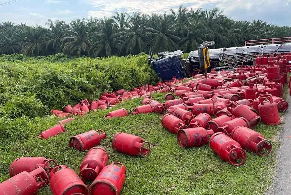 Muatan tong gas bertaburan selepas treler terbalik.