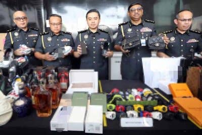 Mohd Zuhairi (tengah) menunjukkan barang rampasan yang dilupuskan pada Selasa.