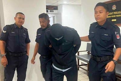 Tertuduh (dua dari kanan) ketika dihadapkan ke Mahkamah Sesyen Kuala Terengganu pada Selasa atas 13 pertuduhan membabitkan kesalahan seksual terhadap pelajarnya.