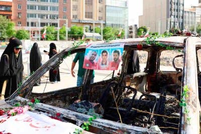 Rakyat Iran memeriksa ambulans Bulan Sabit Merah Iran yang musnah semasa serangan Israel, di Teheran pada Isnin. Foto AFP