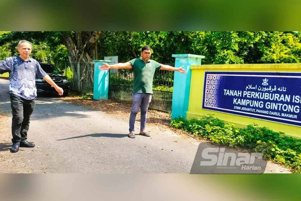 Shahril Nizam (kanan) dan Razak menunjukkan jarak antara tapak perkuburan dan tebing sungai. Foto Sinar Harian