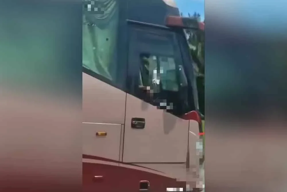 Tangkap layar video tular yang memaparkan pemandu bas ekspres memandu secara melulu dan memotong di laluan kecemasan di Lebuhraya Utara Selatan, Kulai.