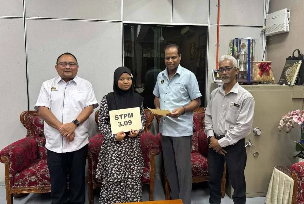 Kesavan (dua dari kanan) menyampaikan sumbangan kepada Sira atas kejayaan pelajar itu meraih keputusan cemerlang dalam STPM. Foto Ihsan pembaca