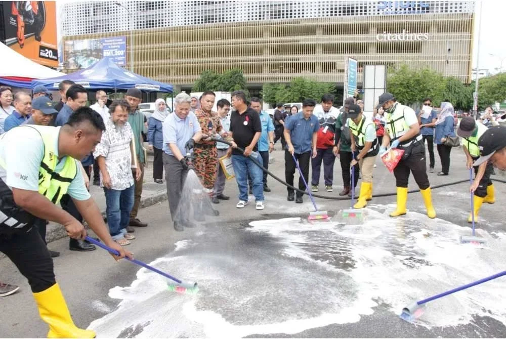 Sabin (tga dari kiri) ketika bergotong royong selepas melancarkan Kempen Membasmi Tikus di sekitar Pasar Besar Kota Kinabalu.