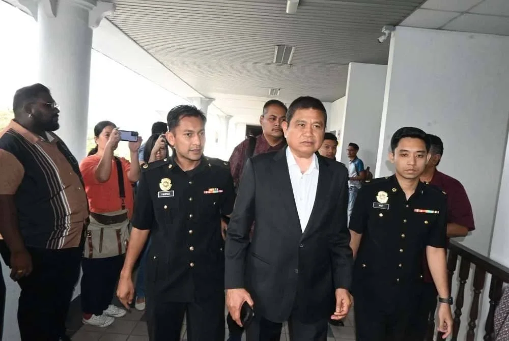 Mohamad Ali (tengah) hadir di Mahkamah Sesyen Melaka bagi pertuduhan kes menerima suapan kereta mewah bagi projek tambakan laut.