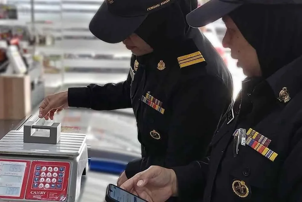 Anggota penguat kuasa KPDN Selangor memeriksa penimbang di sebuah premis perniagaan dalam operasi dijalankan.