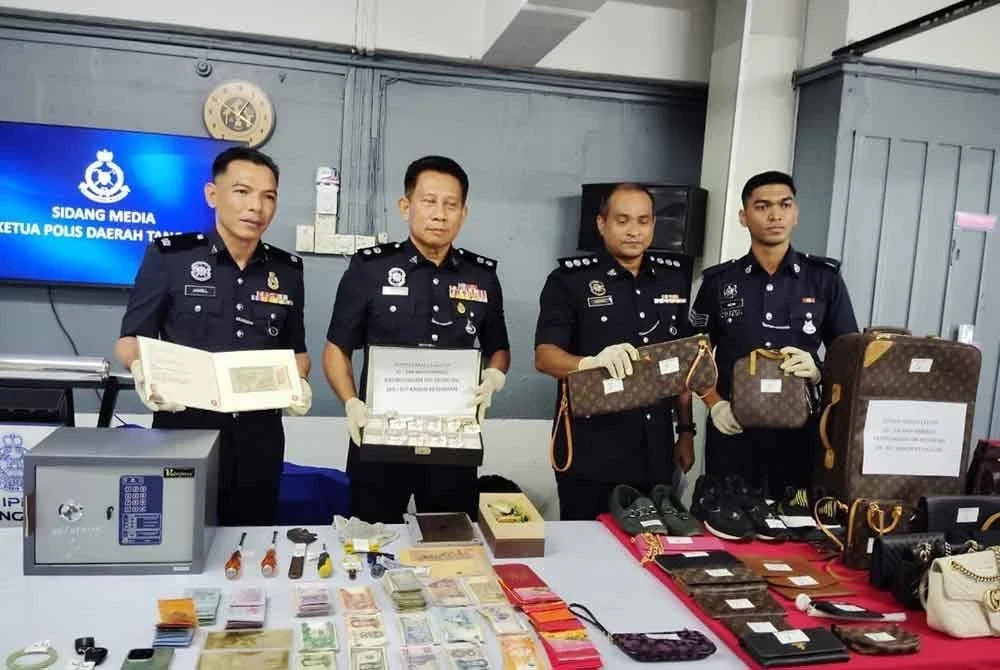 Roslan (dua dari kiri) menunjukkan barangan yang dirampas.