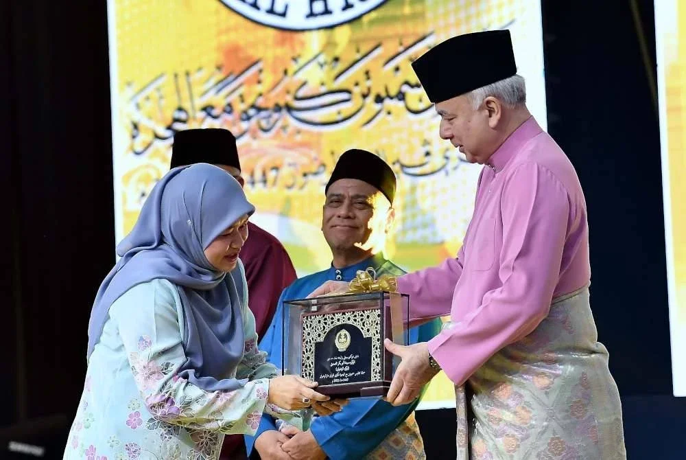 Sultan Perak Sultan Nazrin Shah berkenan menyampaikan Anugerah Saidina Abu Bakar (Tokoh al-Riduan) kepada tokoh ilmuan Islam dan perundangan terkenal iaitu Almarhumah Datin Dr Siti Zalikhah Md Nor yang diwakili Menteri Pendidikan Fadhlina Sidek (kiri) yang juga anak kepada Almarhumah Datin Dr Siti Zalikhah Md Nor sempena Majlis Sambutan Maal Hijrah 1447H Peringkat Negeri Perak di Dewan Convention Casuarina, Meru pada Khamis. Foto Bernama