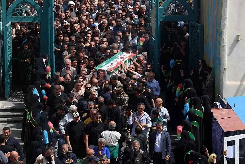 Para penziarah berjalan dalam perarakan pengebumian seorang askar Iran yang terkorban dalam serangan Israel beberapa hari lalu, di Tehran pada 26 Jun 2025. Foto AFP