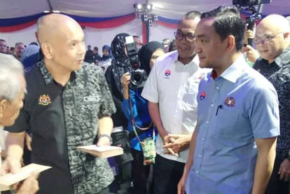 Onn Hafiz (kiri), berkata sesuatu kepada Amir an ketika menyampaikan sumbangan asnaf pada Karnival berkenaan.