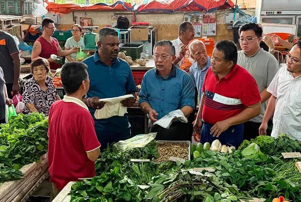 Arul (kiri) meninjau penggunaan beg plastik biodegradasi di Pasar Basar Seremban pada Sabtu.