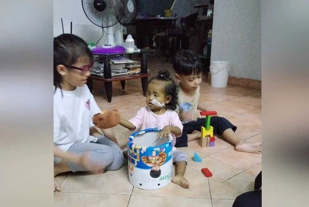 Nina (tengah) bermain-main bersama abang serta kakaknya.