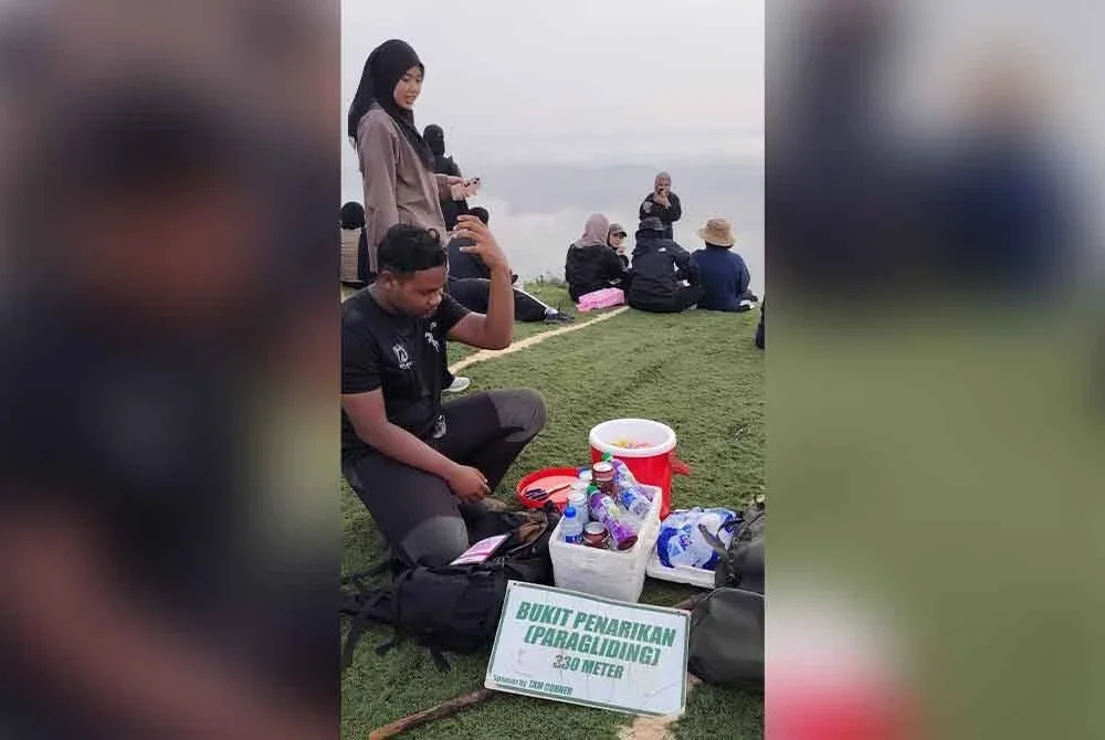 Anak Zashahrina (kiri) menjual aiskrim dan air tin di puncak Bukit Penarikan di Jempol.