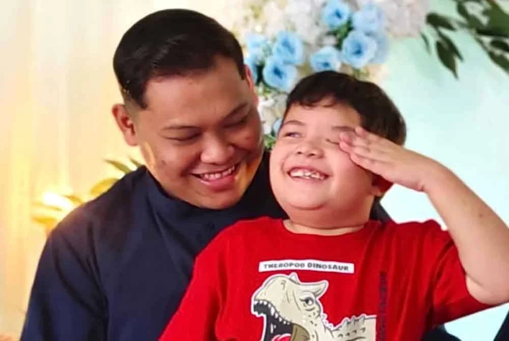 Muhammad Fariz Iskandar yang duduk di riba Muhammad Fariz Izwan.