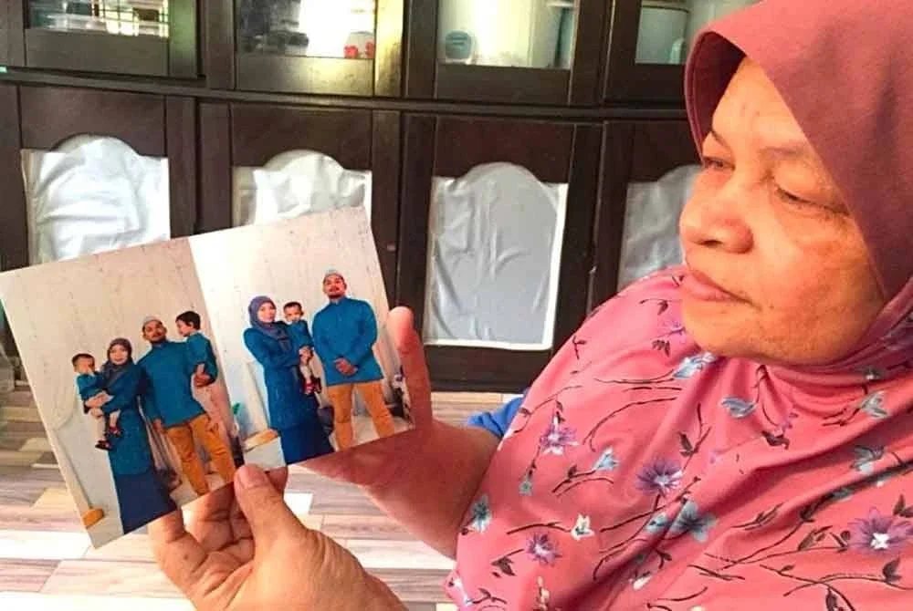 Che Senah (kanan) menunjukkan gambar keluarga anaknya yang terbabit nahas.