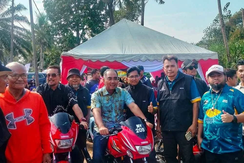 Ridzuan (tengah) tiba di Pesta Sukan Rakyat 2025 diiringi konvoi motosikal penduduk kampung.